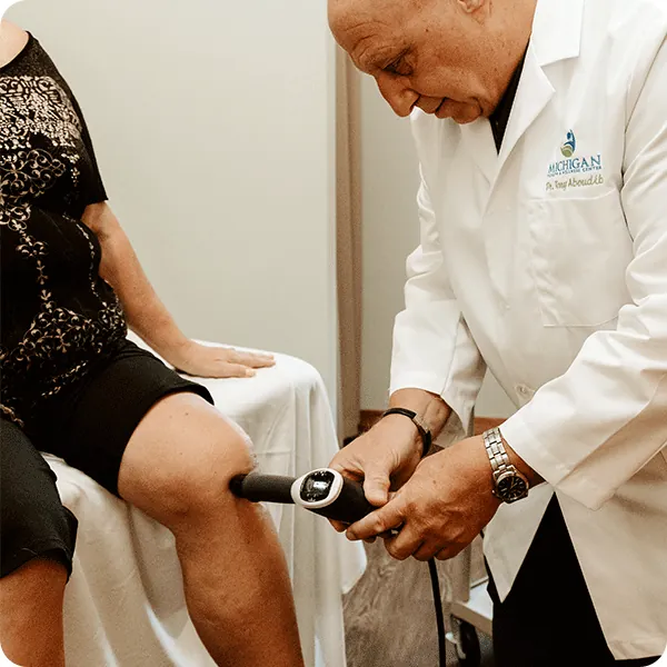 Doctor Tony performs shockwave therapy on female patient's knee