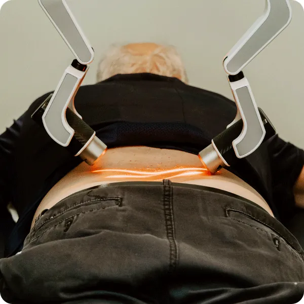 A patient receiving cold laser treatment on the lower back